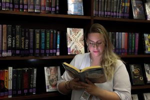 Lisa Detweiler-Miler mysteriously reads book in the library. Miler believes that both AP Literature and Dual  Credit English have benefits for students.