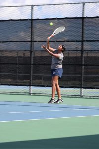 A varsity tennis player practices her swings with her partner for their upcoming game. The varsity tennis team has been working as a team to practice for their solo games in the spring following their triumphant fall season. 