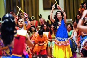 Garba celebrants lively dance around each other, with smiles ear from ear.  Garba is a traditional dance performed during Navratri. 