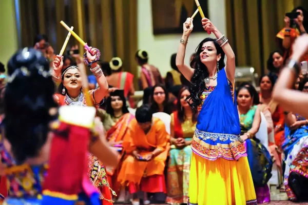Garba celebrants lively dance around each other, with smiles ear from ear.  Garba is a traditional dance performed during Navratri. 