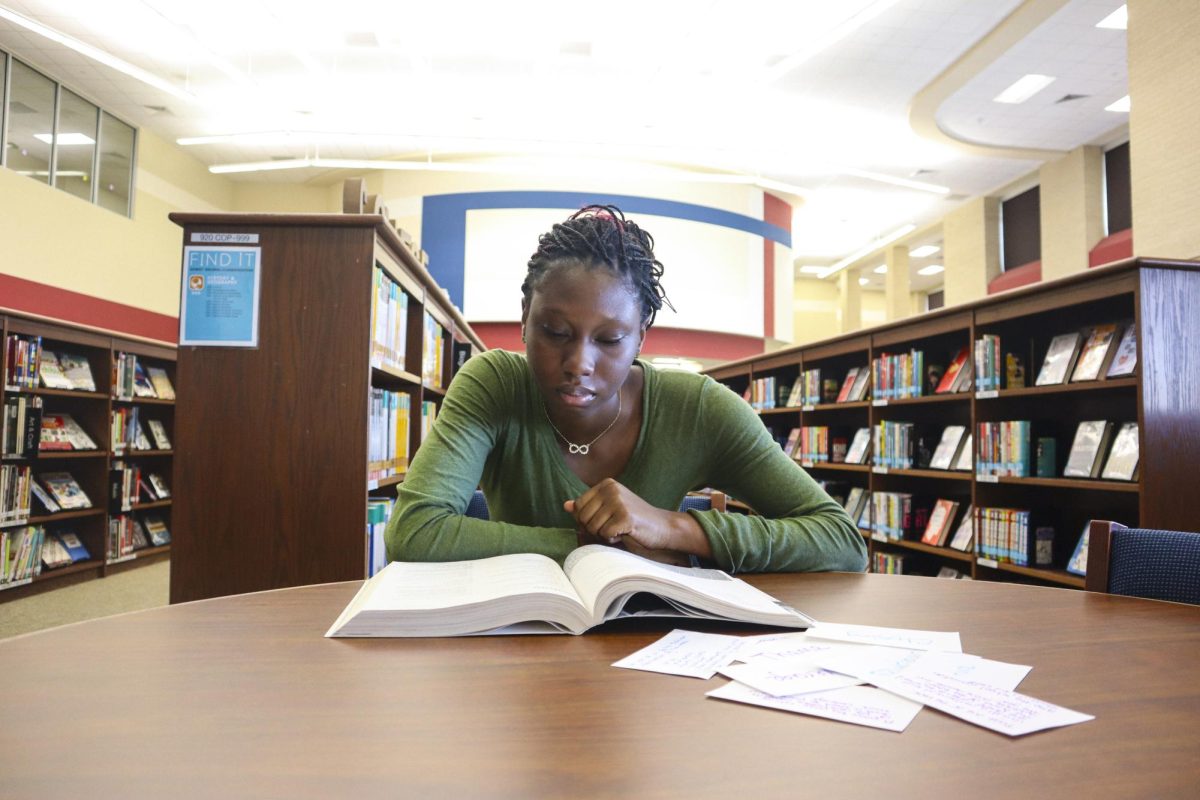 Zainob Azeez studies for her upcoming test in Physics. She uses flashcards and textbooks to ensure that she retains all the information needed.