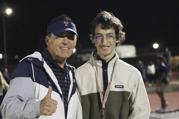 Coach Todd McVey and Nathan Ingles pose together on the sideline at a varsity football game during playoffs. Sapphira Valdez, the Vice President of Best Buddies- OTHS, escorted Nathan down on the field as a way to get Nathan closer to the action. 