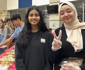 President, Sarah Ahmed, a senior at Tompkins, passes out food at the annual Best Buddies Friendsgiving Celebration. 